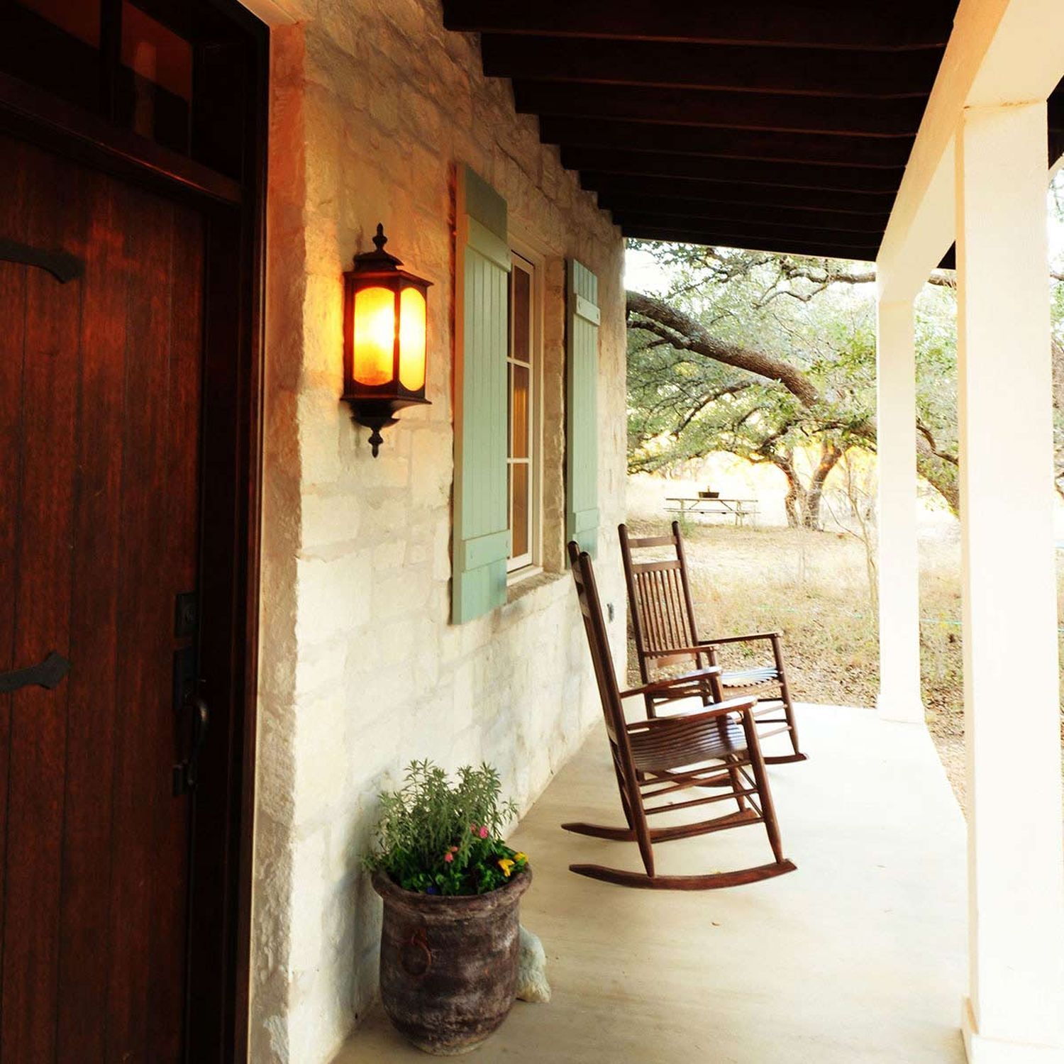 Veranda, Schaukelstuhl, Natursteinmauer, Außenlaterne, Topfpflanze